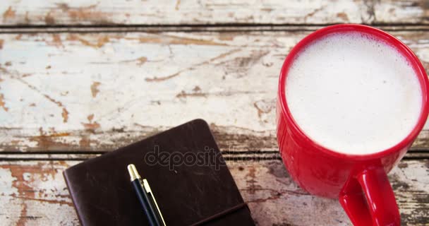 Caneca de café e diário na prancha de madeira — Vídeo de Stock