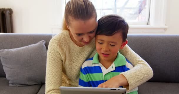 Mother and son using digital tablet in living room — Stock Video