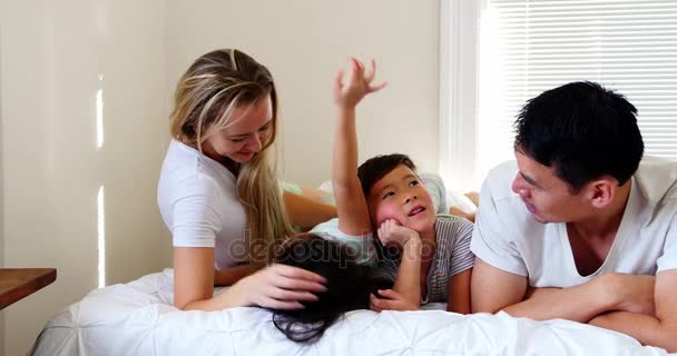 Famille heureuse se détendre sur le lit — Video