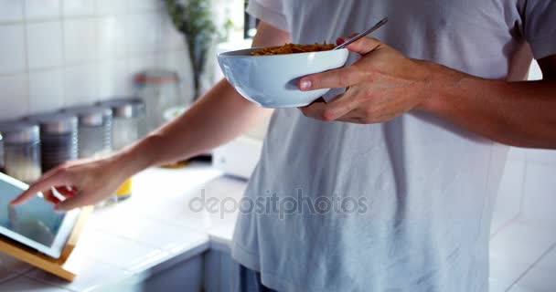 Mujer usando tableta digital mientras desayuna — Vídeos de Stock