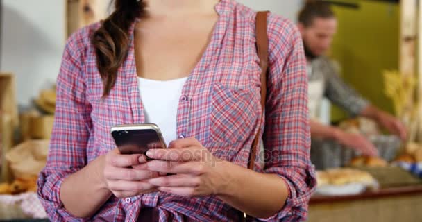 Mujer usando teléfono móvil en la sección de panadería — Vídeos de Stock