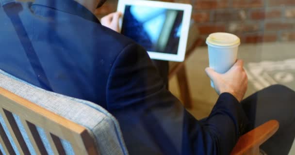 Man using digital tablet while drinking coffee — Stock Video