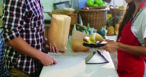 Personal femenino que ayuda al hombre en la selección de frutas frescas — Vídeos de Stock