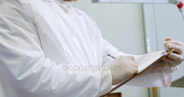 Male butcher writing on clipboard — Stock Video