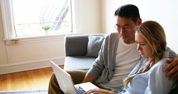 Couple using laptop while relaxing on sofa — Stock Video