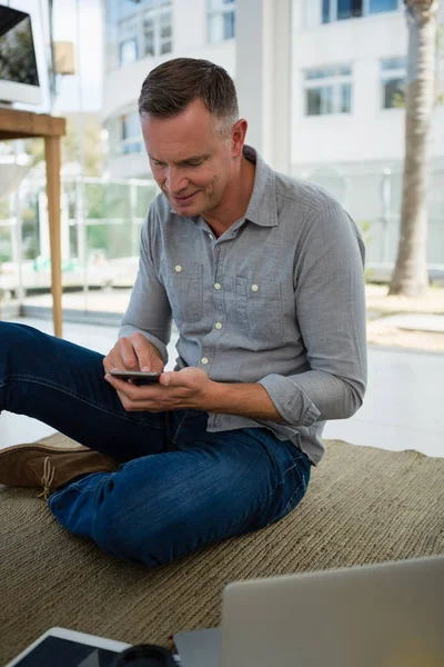 Smiling designer using smart phone — Stock Photo, Image