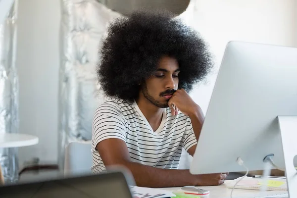 Mann mit lockigem Haar benutzt Computer — Stockfoto