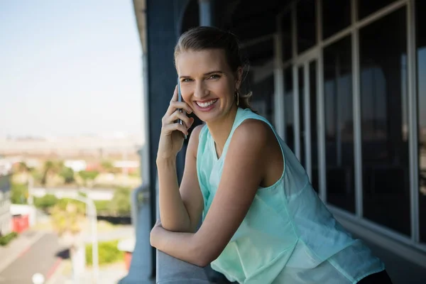 Mujer hablando por teléfono en el balcón de la oficina — Foto de Stock