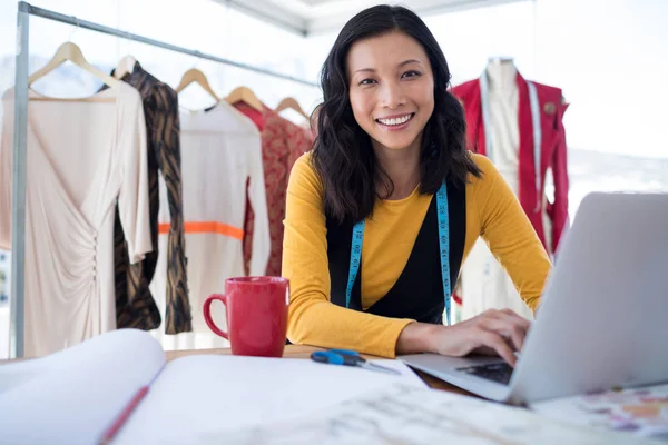 Diseñador femenino usando el ordenador portátil — Foto de Stock