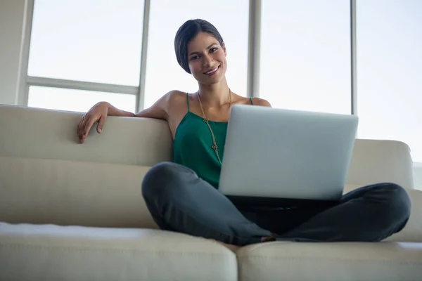 女人在办公室的沙发上使用笔记本电脑 — 图库照片
