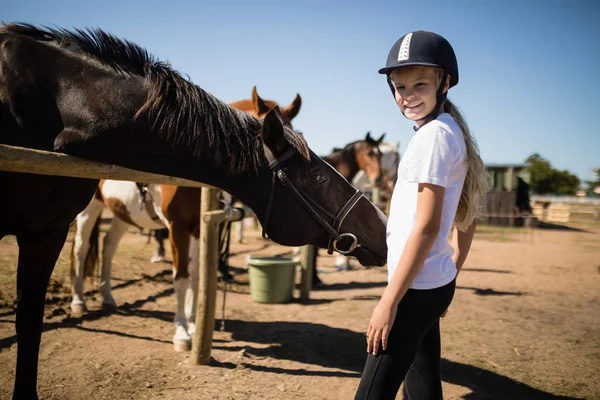 Menina de pé perto do cavalo no rancho — Fotografia de Stock