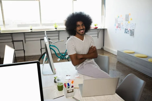 Sorrindo homem sentado na mesa no escritório — Fotografia de Stock