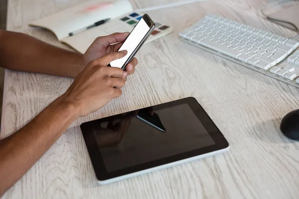 Pria menggunakan telepon melalui tablet di kantor — Stok Foto