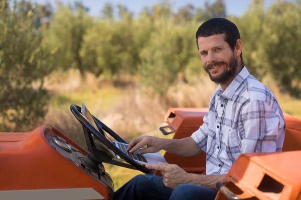 Homme heureux en utilisant un ordinateur portable en tracteur — Photo