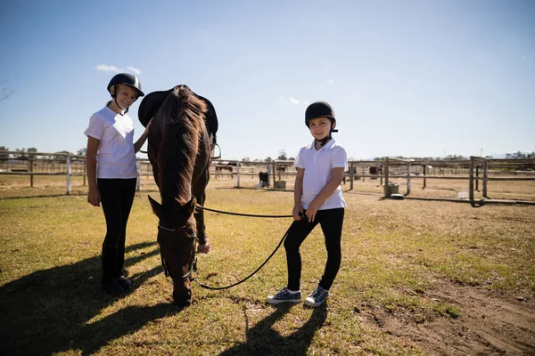 Meninas de pé na fazenda com casa marrom — Fotografia de Stock