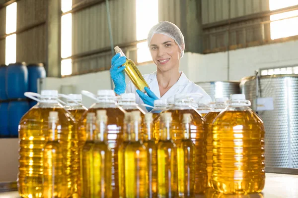 Técnico femenino examinando aceite de oliva —  Fotos de Stock