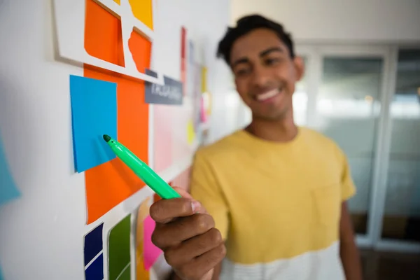 Homme pointant vers des notes collantes avec un stylo feutre au bureau — Photo