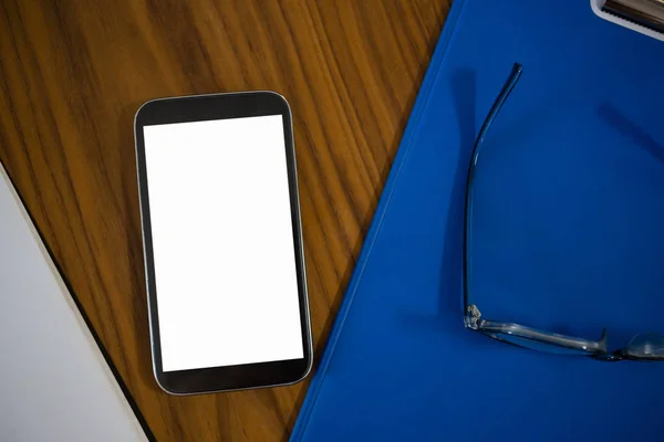 Telefone e área de transferência na mesa no escritório — Fotografia de Stock