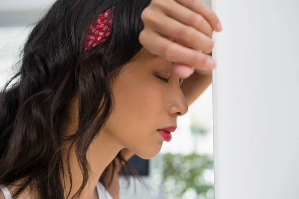 Businesswoman with eyes closed leaning on wall — Stock Photo, Image