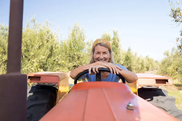 Femme heureuse assise dans le tracteur — Photo