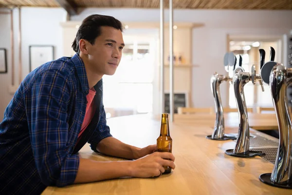 Человек, пьющий пиво за стойкой — стоковое фото