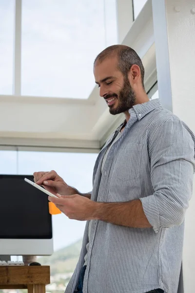 Designer using tablet while leaning on wall — Stock Photo, Image