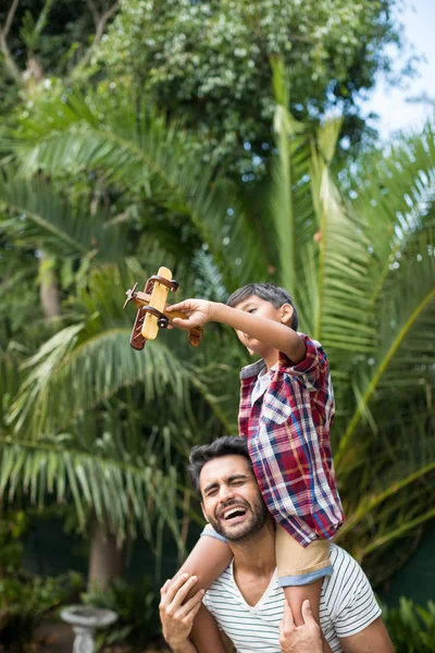 Pai carregando filho enquanto em pé no quintal — Fotografia de Stock