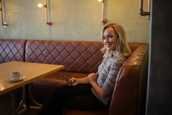 Femme utilisant le téléphone portable dans le restaurant — Photo