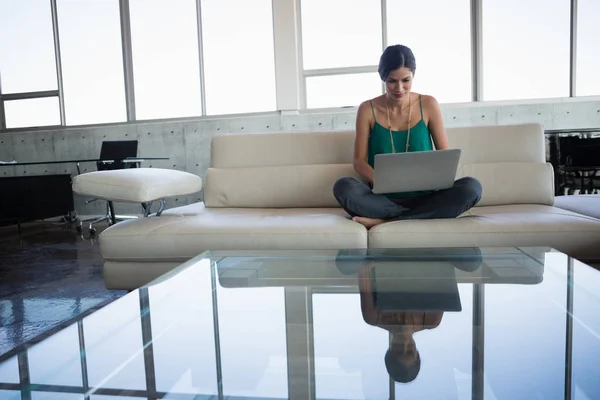Wanita menggunakan laptop saat duduk di sofa — Stok Foto