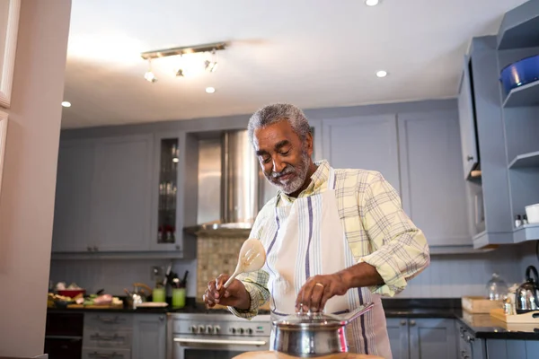 Senior homme préparant la nourriture dans la cuisine — Photo