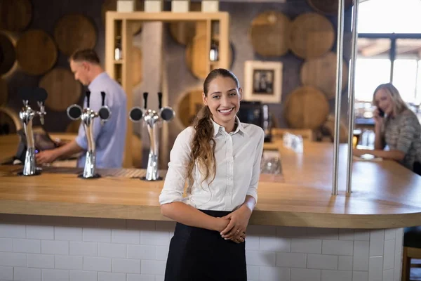 Female bartender standing near bar counter — Stock Photo, Image