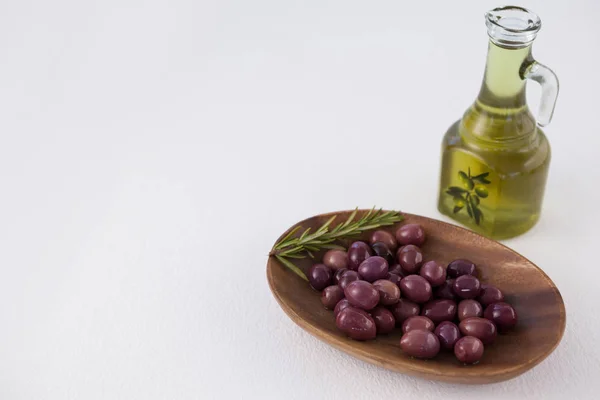 Aceitunas marrones en plato por aceite en frasco — Foto de Stock