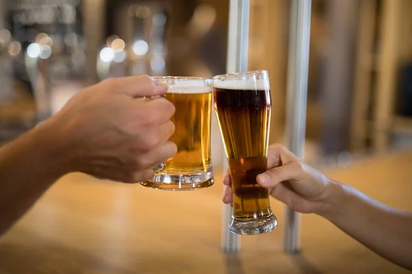 Casal brindar copo de cerveja no balcão do bar — Fotografia de Stock