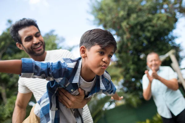 Abuelo mirando al hombre jugando con su hijo —  Fotos de Stock