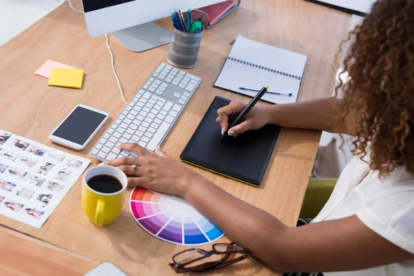 Ejecutivo femenino trabajando sobre tableta gráfica — Foto de Stock