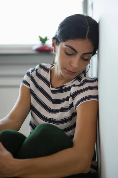 Trött kvinna sover av väggen på kontoret — Stockfoto