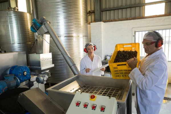 Arbeiter arbeiten in der Nähe der Produktionslinie zusammen — Stockfoto