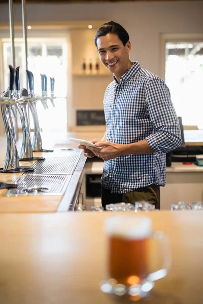 Bartender hält digitales Tablet am Tresen — Stockfoto