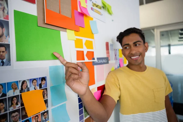 Man pointing at sticky notes in office — Stock Photo, Image