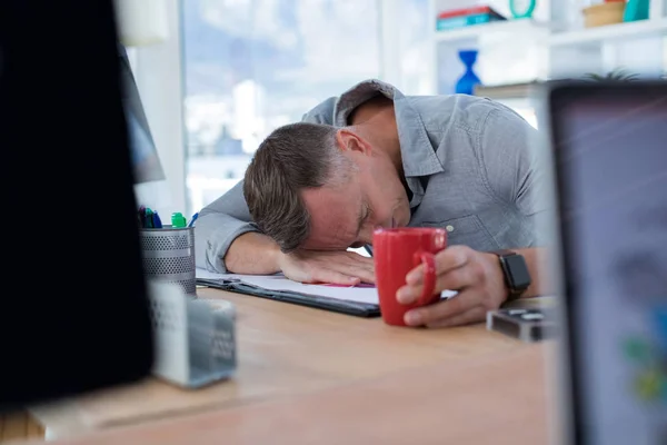 Müder männlicher Manager schläft auf Schreibtisch — Stockfoto