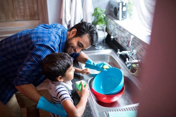 Vader en zoon schoonmaken van gebruiksvoorwerpen thuis — Stockfoto