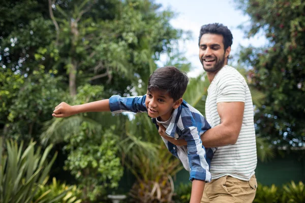 Pai brincalhão brincando com filho no quintal — Fotografia de Stock