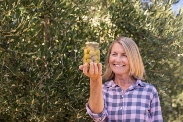 Wanita memeriksa zaitun acar di peternakan — Stok Foto