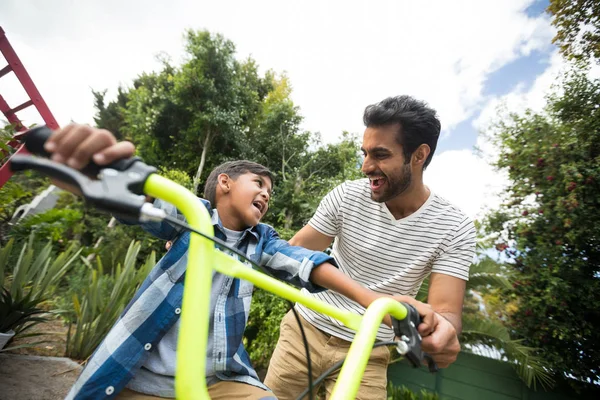 Vader van meewerkende zoon tijdens het rijden van de fiets — Stockfoto