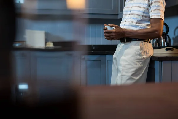 Homem tomando café enquanto em pé pela cozinha — Fotografia de Stock