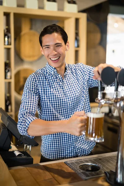 Bartender füllt Bier aus der Zapfsäule — Stockfoto