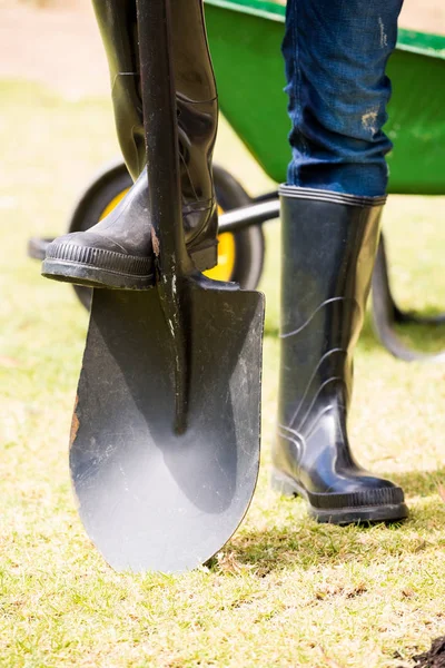 Man in rubber boot with shovel — Stock Photo, Image