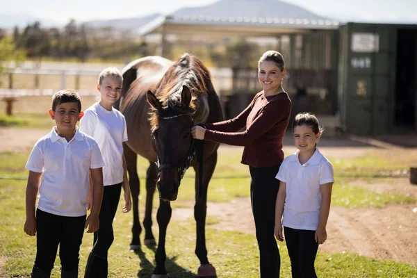 Família de pé com cavalo marrom — Fotografia de Stock