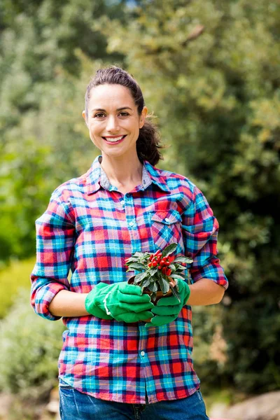 Vrouw met ingemaakte plant tegen bomen — Stockfoto