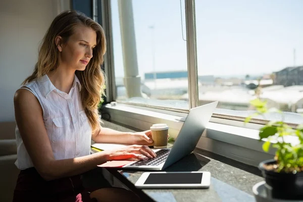 Zakenvrouw werken tijdens het gebruik van laptop — Stockfoto
